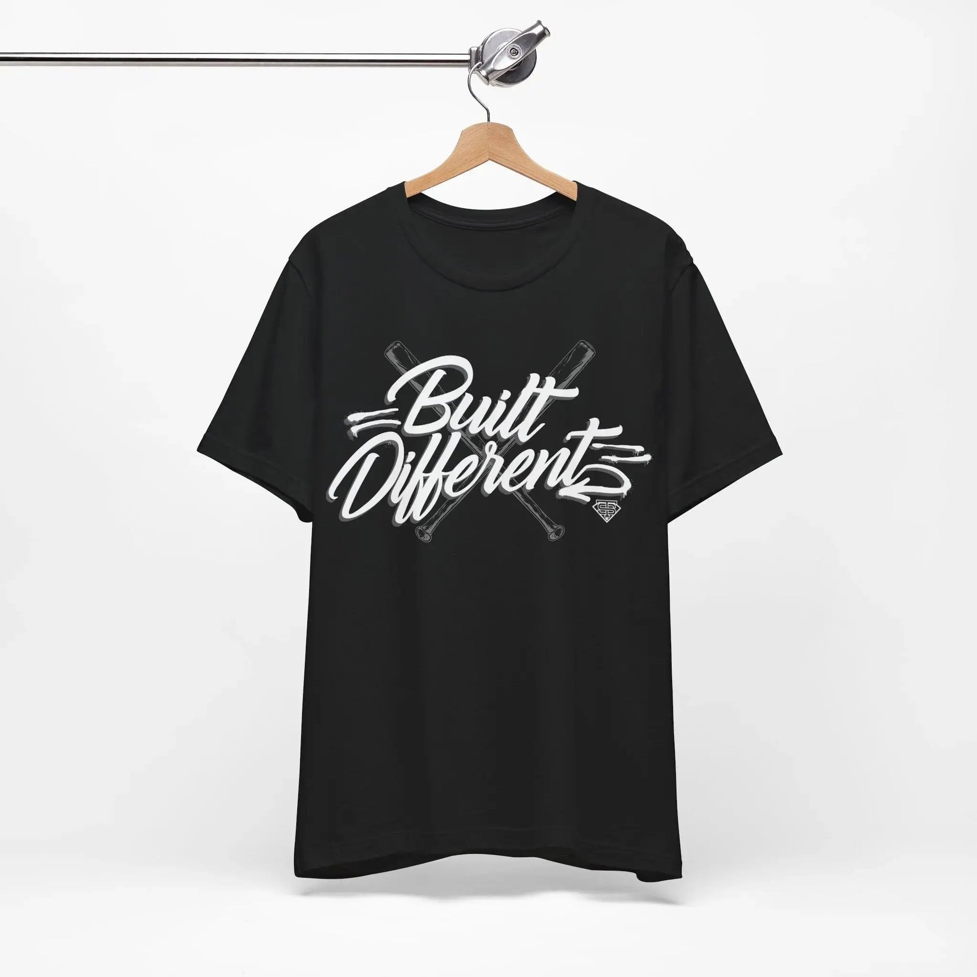 Black t-shirt with 'Built Different' text on a hanger against a white background