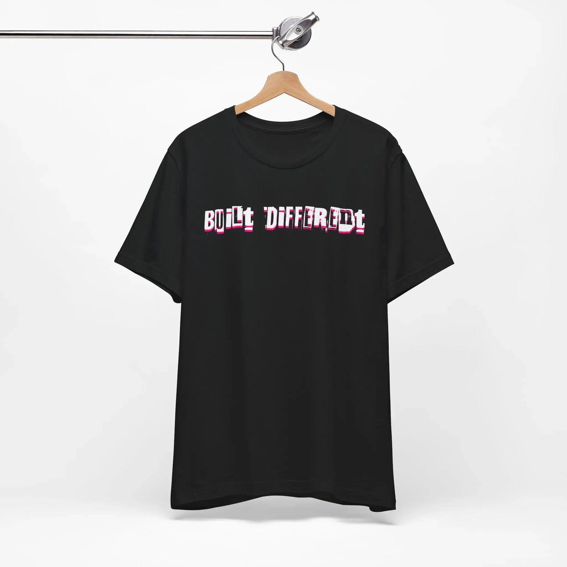 Black t-shirt with 'Built Different' text on a hanger against a white background