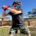 Young baseball player wearing camo athletic shorts during batting practice and training