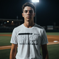 Person wearing a white t-shirt with text on a baseball field at night